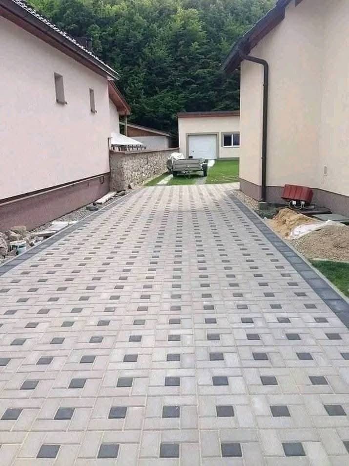 Completed grey and charcoal block paved driveway between two houses